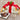 Gift box with a red ribbon and chocolate truffles on a wooden surface