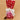 Gift bag with pink chocolates and a white bow on a brown background